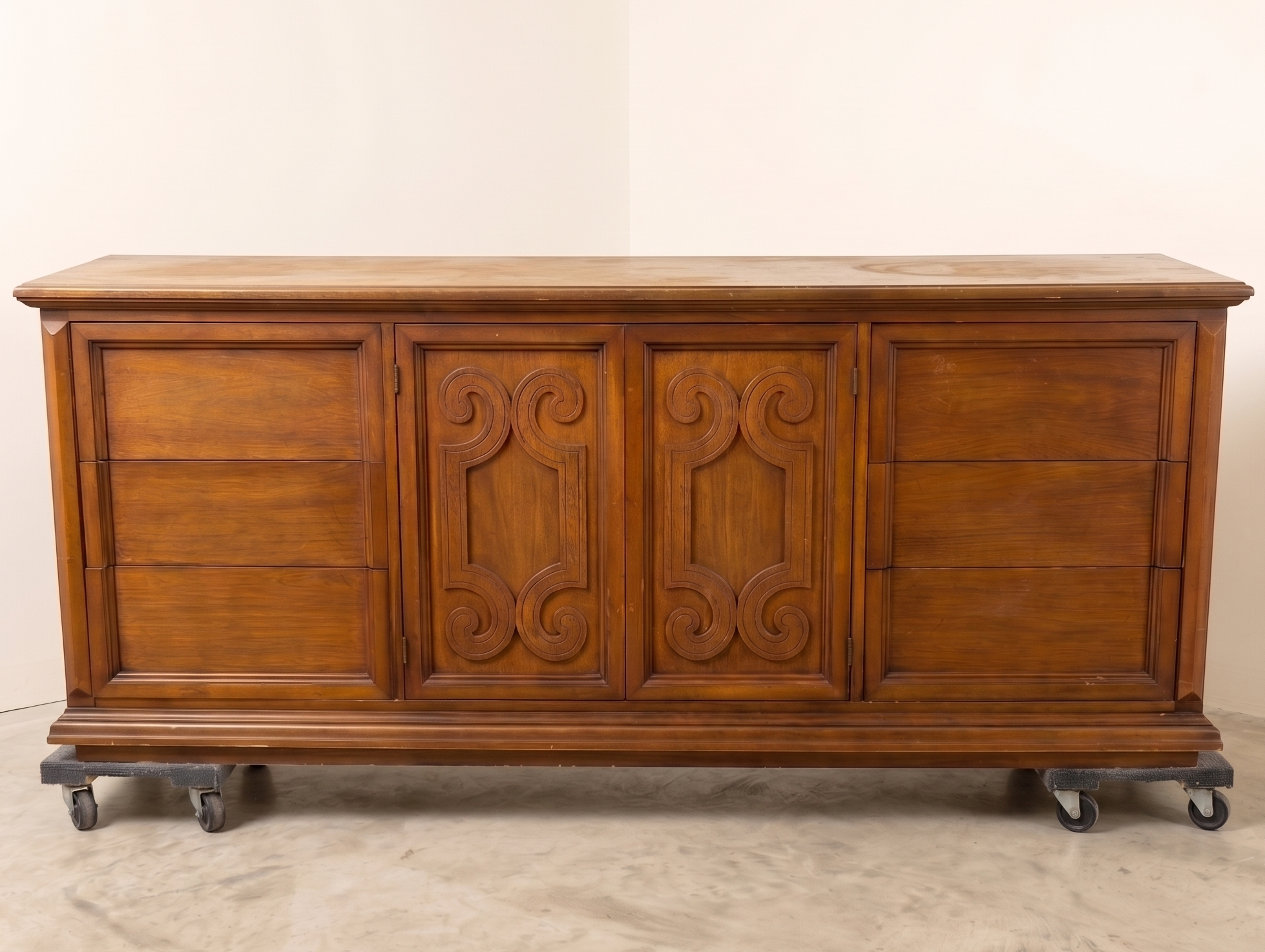 Wooden dresser with decorative carvings on a plain background